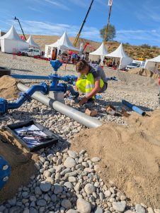 apprenti accroupi fixe une canalisation